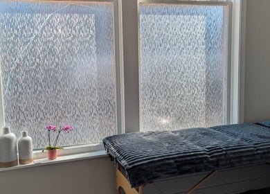Relaxing massage table near frosted windows at The Backdoor Wax Studio in Trail, British Columbia, CA.