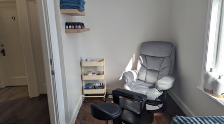 Relaxing corner at The Backdoor Wax Studio in Trail, British Columbia, CA with a plush chair and beauty products.
