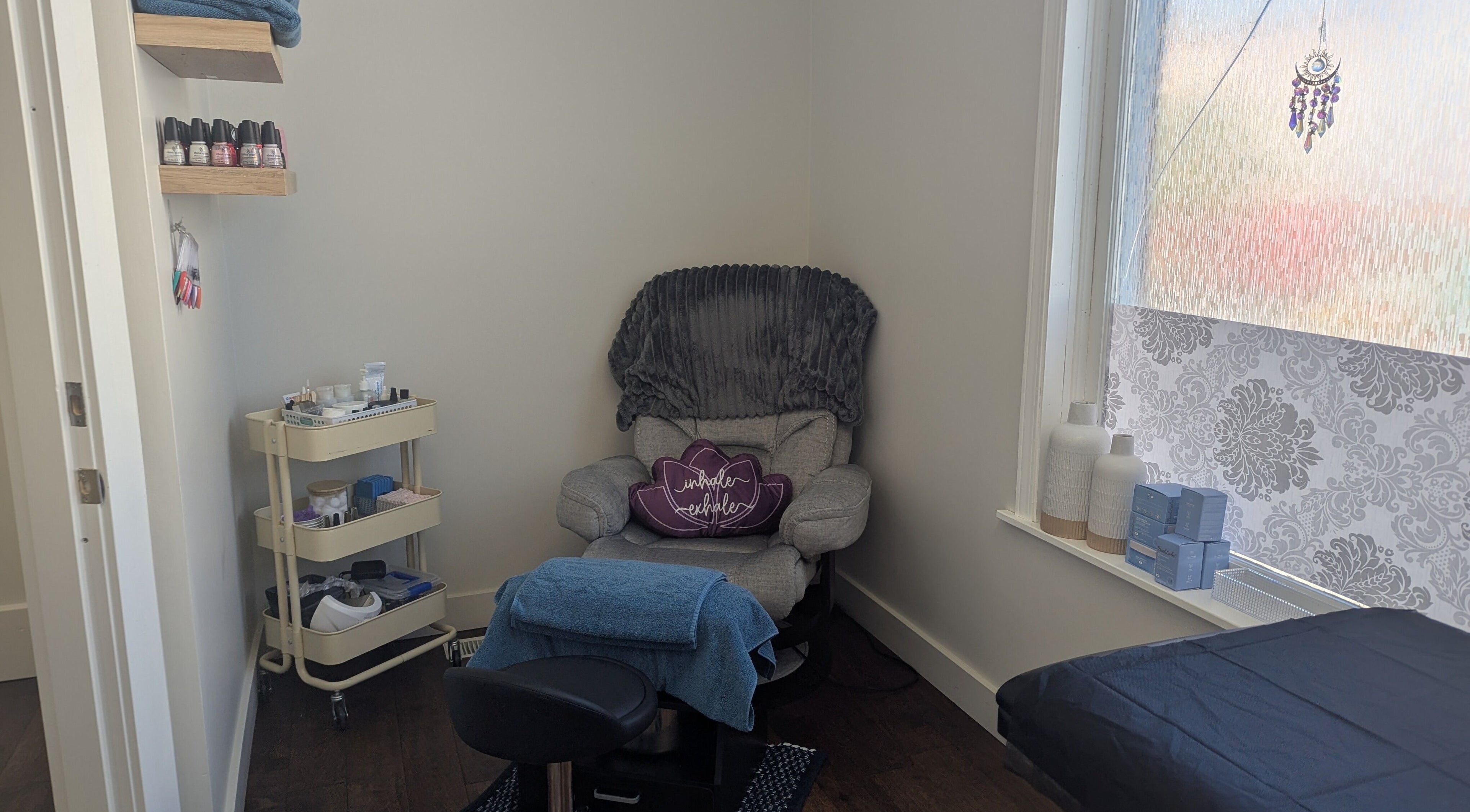 Relaxing corner at The Backdoor Wax Studio in Trail, British Columbia, CA, featuring a plush chair and essentials.