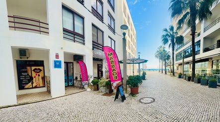 Entrance to Talay Thai Massage Therapy in Quarteira, Faro, PT with vibrant display signs and beach view.