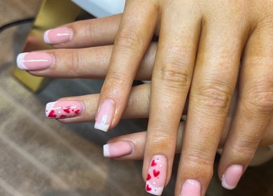 Detail of pink French manicure with heart designs at Nailsbymaddymae, Brighton And Hove, England, GB.