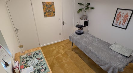 Tranquil massage room at Muscle Ease Sports Massage in Bath, England, GB with a treatment table and decor.