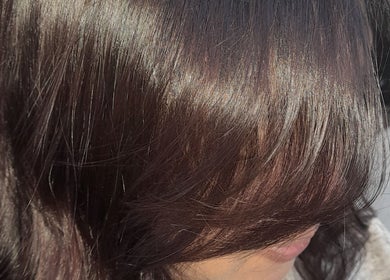 Close-up of shiny brown hair styled at Hair by Me, Cape Town, Western Cape, ZA.