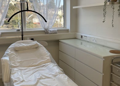 Relaxing treatment room at Aesthetics by Jade, Newton Abbot, England, GB, with a comfy white chair and natural light.