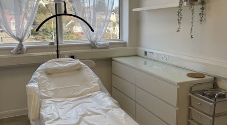 Relaxing treatment room at Aesthetics by Jade, Newton Abbot, England, GB, with a comfy white chair and natural light.