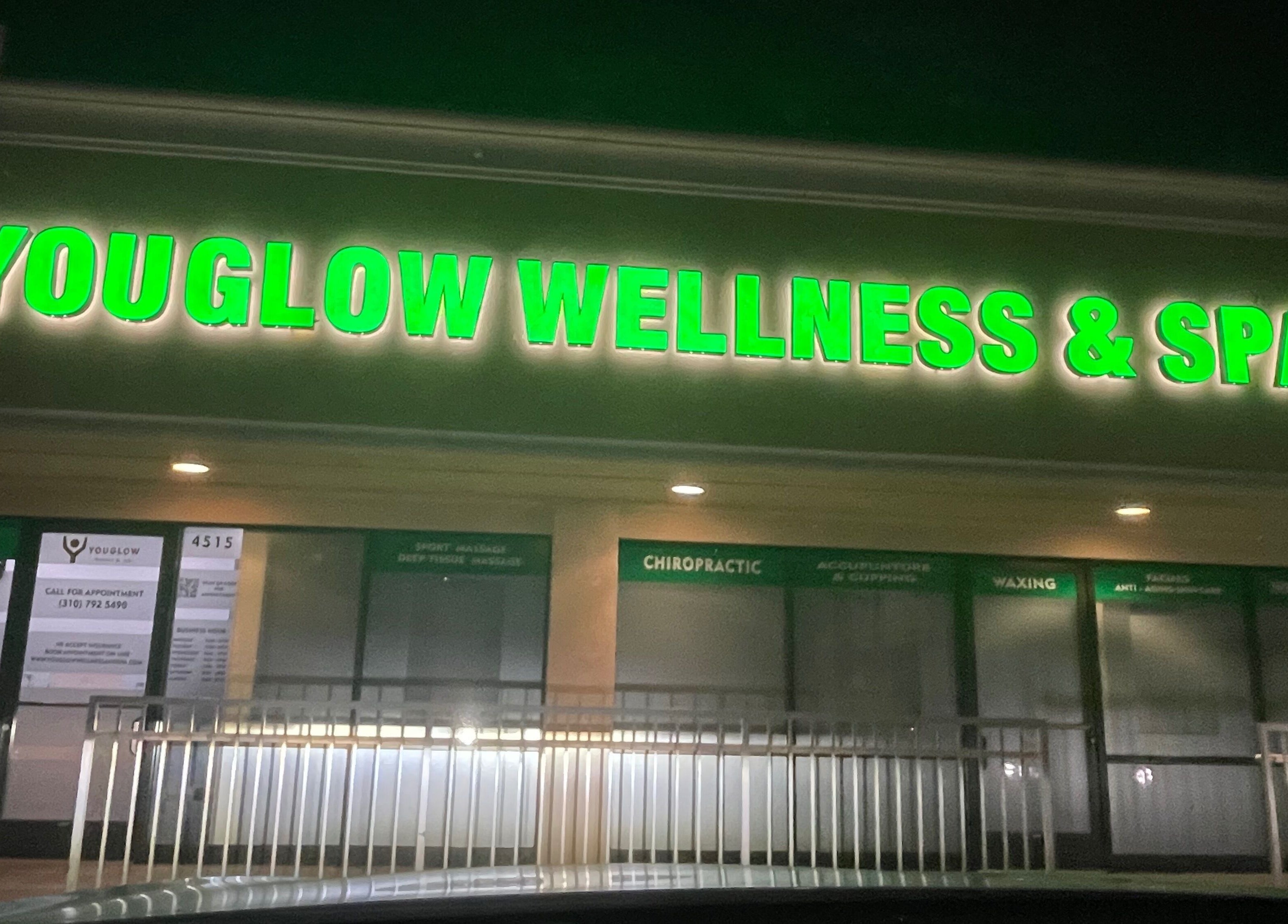 Entrance of Youglow Wellness & Spa in Torrance, California, US, illuminated with vibrant green signage.