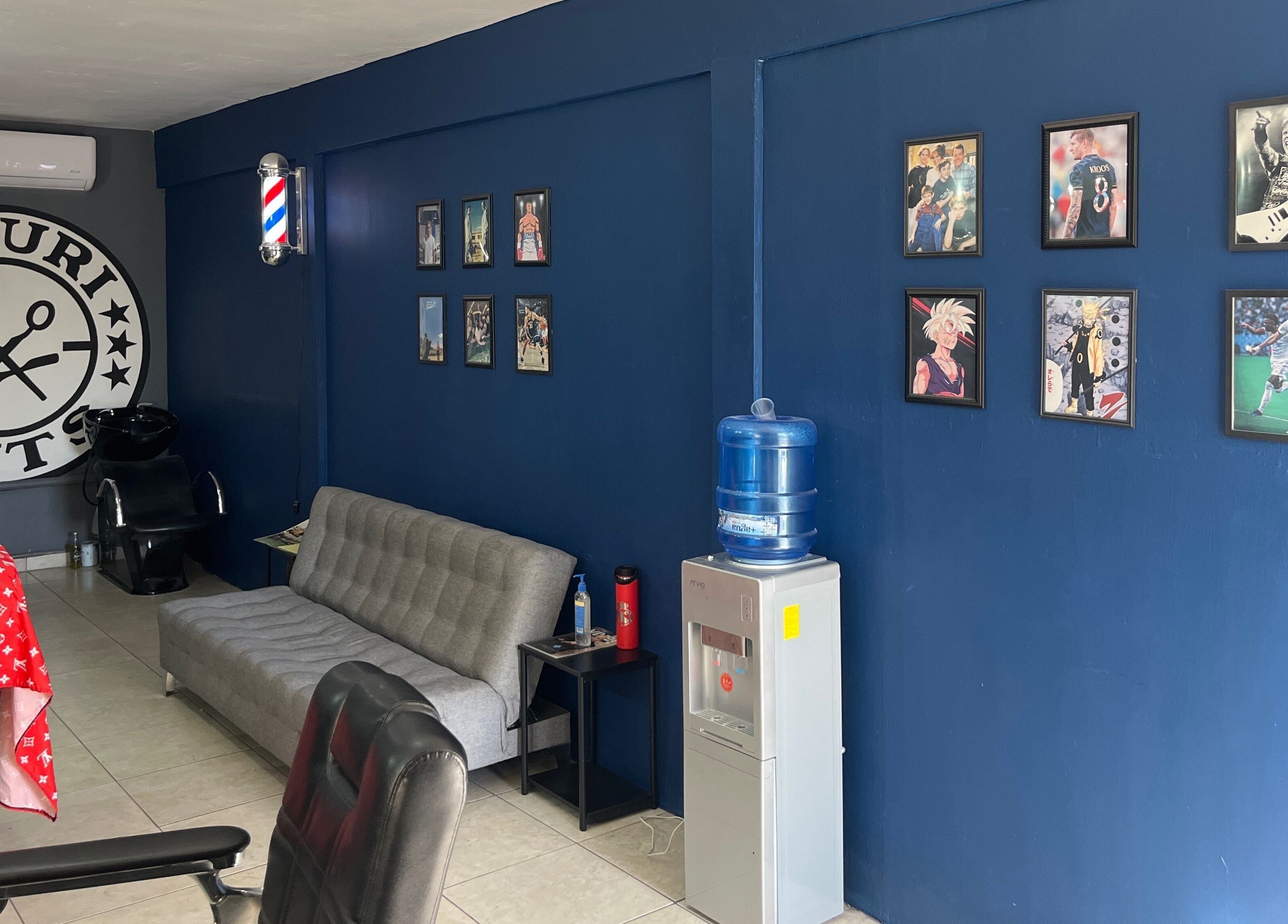 Interior de Mauricuts Barber Shop en Los Mochis, Sinaloa, MX, con decoración vibrante y arte en la pared.
