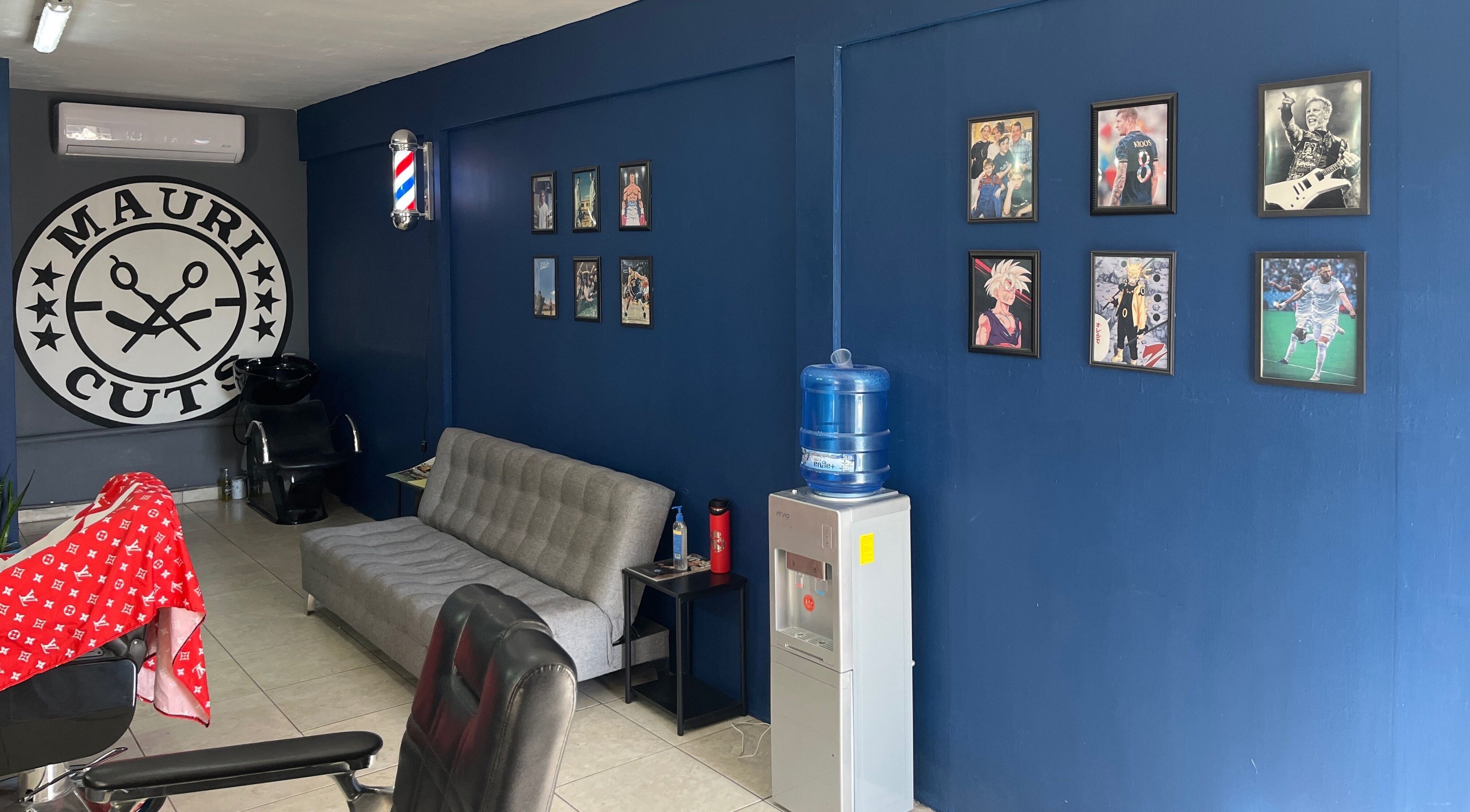 Interior de Mauricuts Barber Shop en Los Mochis, Sinaloa, MX, con decoración vibrante y arte en la pared.