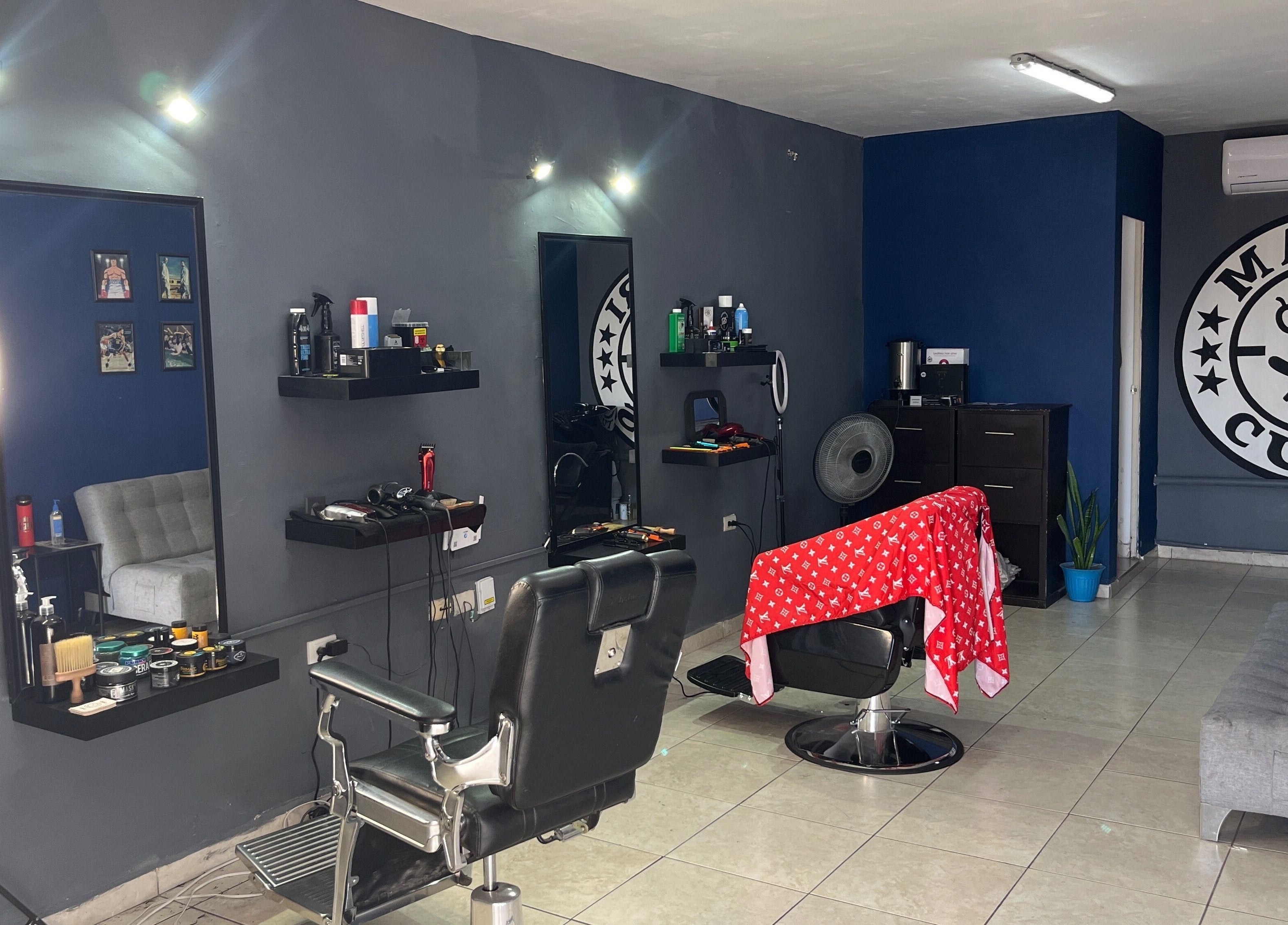 Interior moderno de Mauricuts Barber Shop en Los Mochis, Sinaloa, MX, con sillas y espejos elegantes.