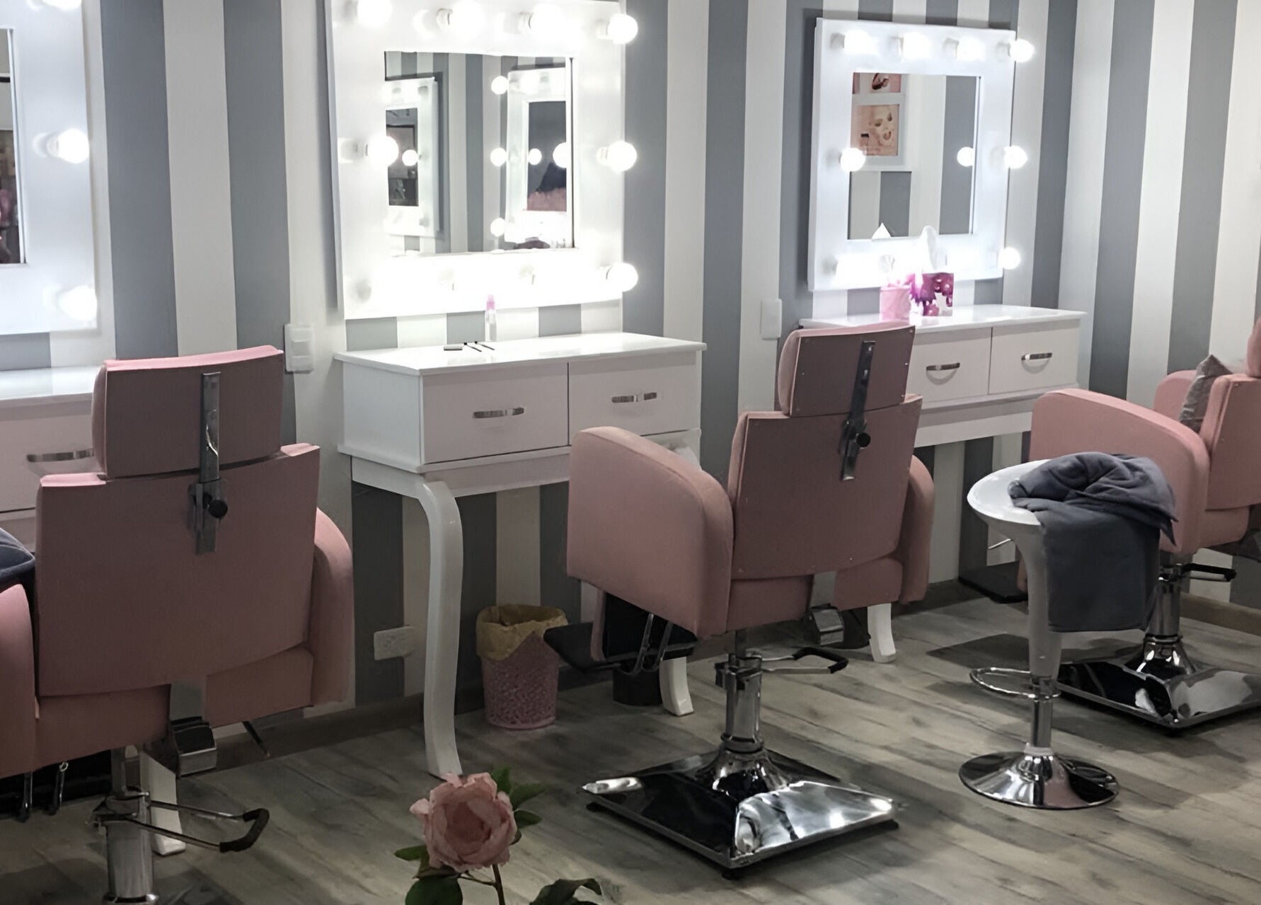 Rincón de belleza en Le Visage Fontanar, Chia, Cundinamarca, CO con sillones rosas y espejos iluminados.