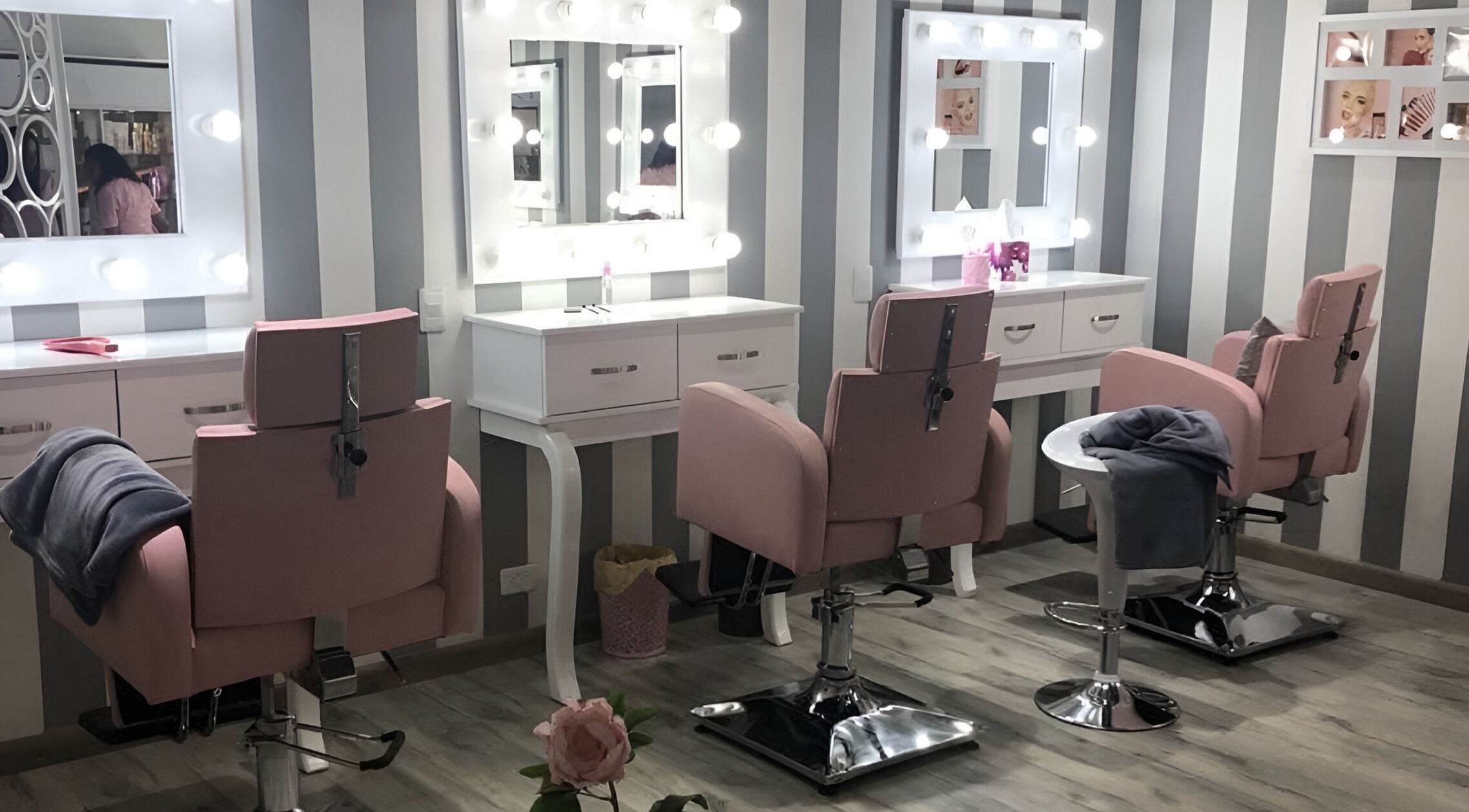 Rincón de belleza en Le Visage Fontanar, Chia, Cundinamarca, CO con sillones rosas y espejos iluminados.