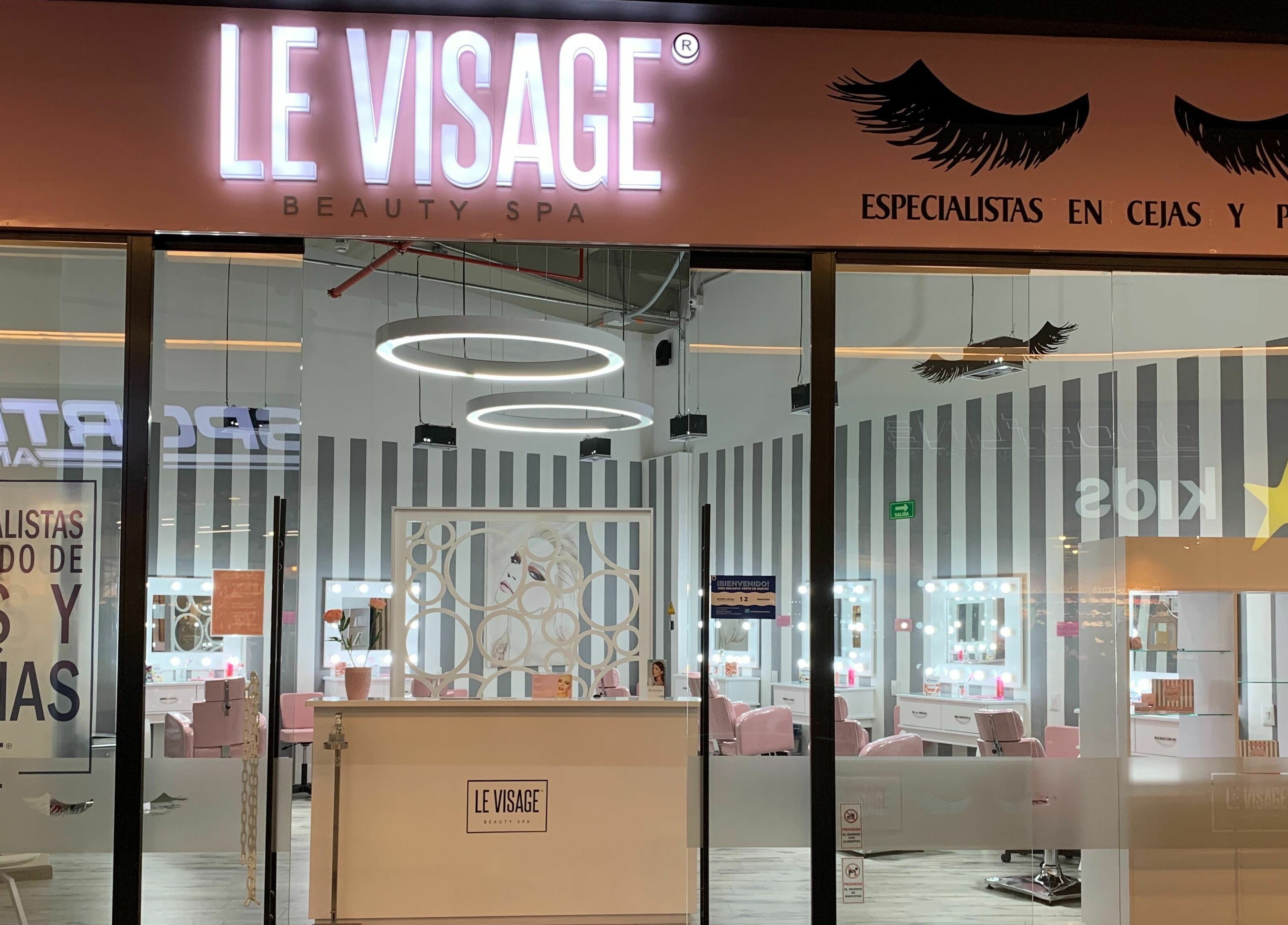 Fachada iluminada de Le Visage Parque la Colina en Bogotá, CO, especializada en cejas y pestañas.