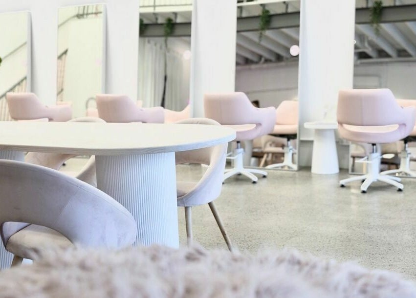 Elegant salon seating area at Rapunzel Rapunzel, North Lakes, Queensland, AU with soft pink chairs and mirrors.