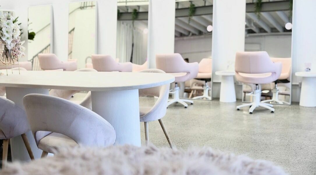 Elegant salon seating area at Rapunzel Rapunzel, North Lakes, Queensland, AU with soft pink chairs and mirrors.