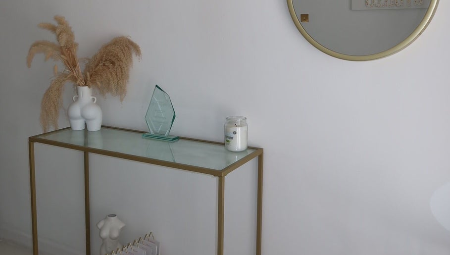 Stylish entryway at The Sculpt Studio EST 2018 in Sketty, Wales, GB with decor and a round mirror.