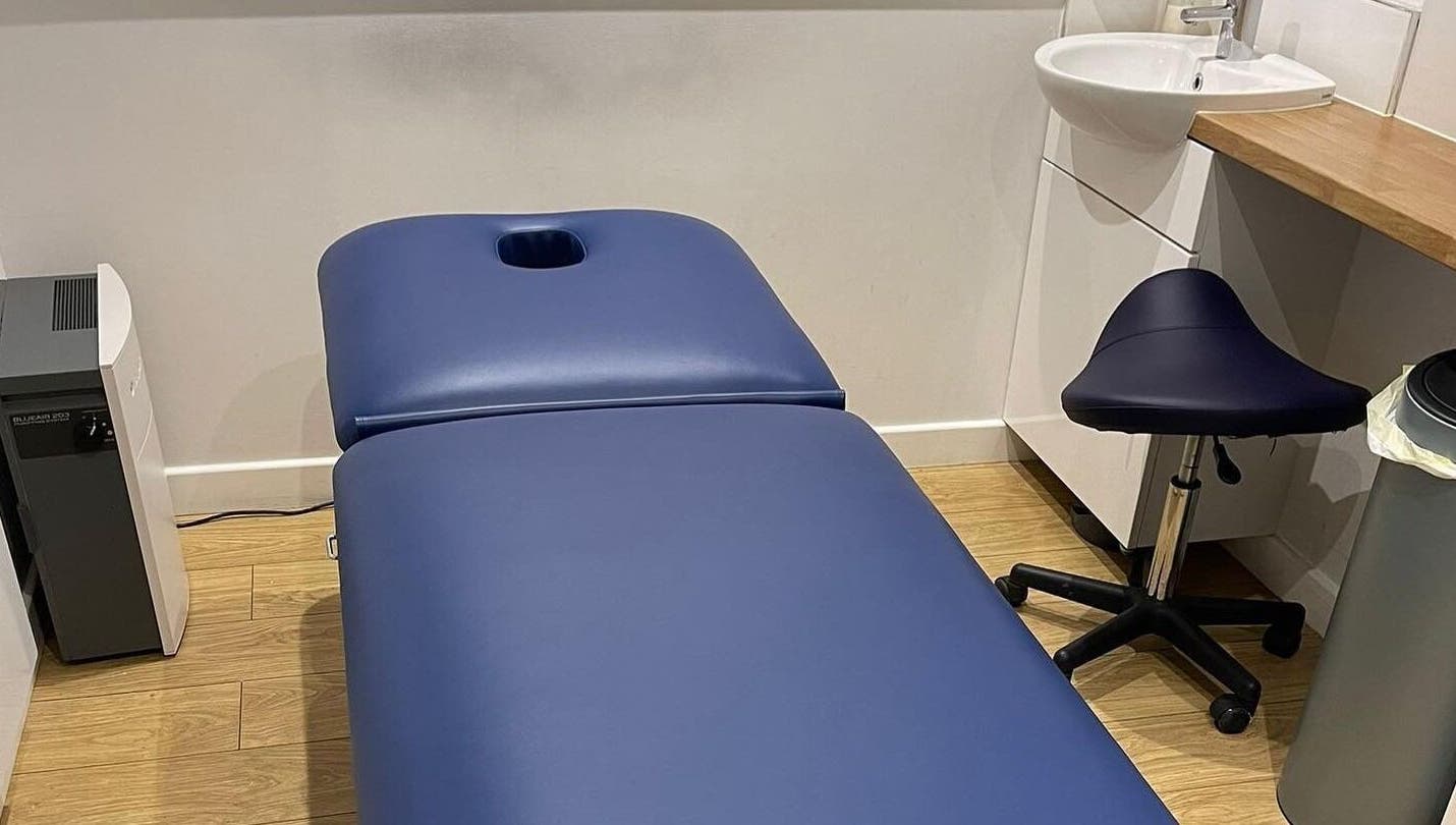 Cozy treatment room at Therapy & Life Centre, Coulsdon, England, GB, with a blue massage table and stool.