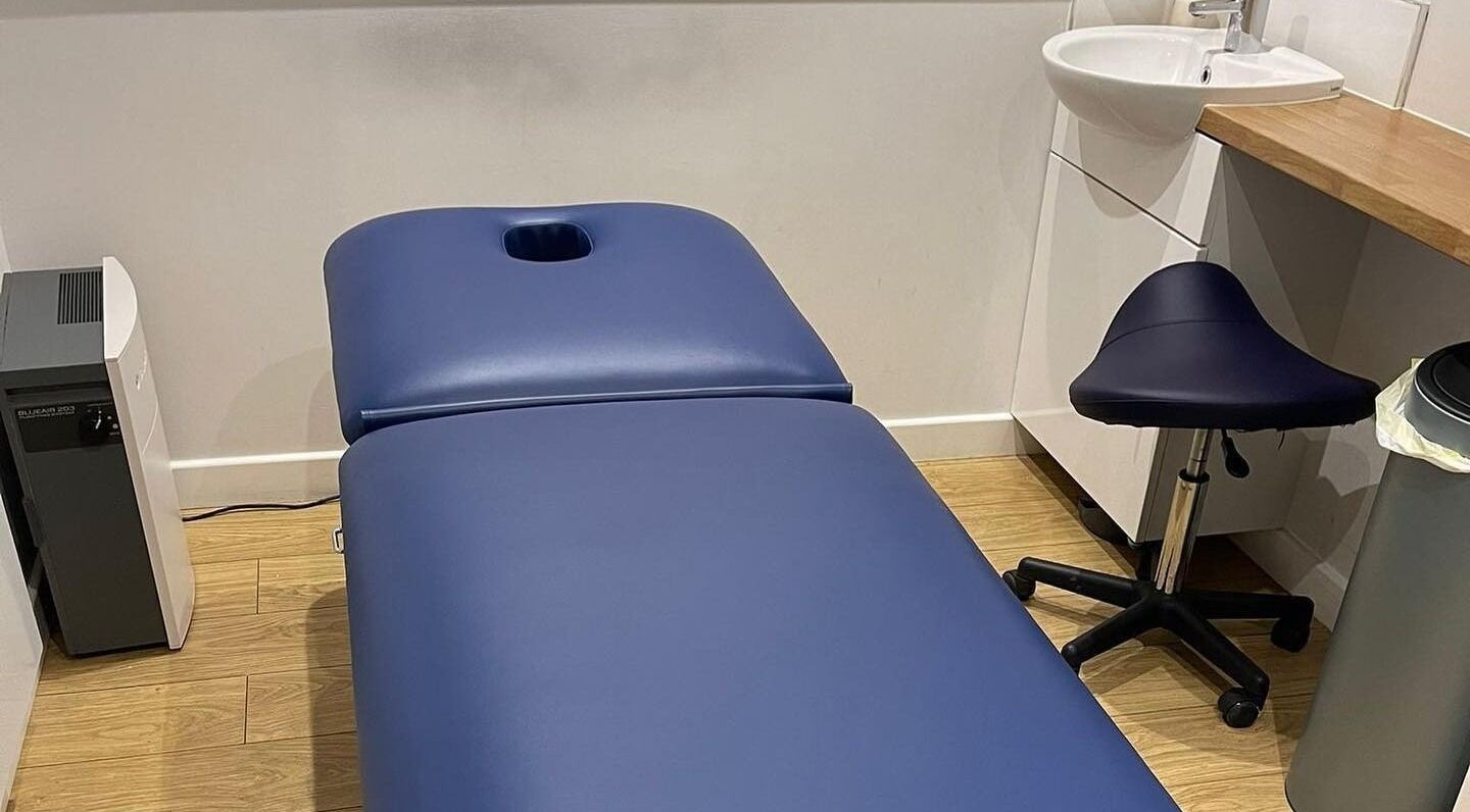 Cozy treatment room at Therapy & Life Centre, Coulsdon, England, GB, with a blue massage table and stool.