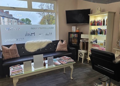 Chic and cozy waiting area at Erika’s Beauty in Derby, England, GB, showcasing plush seating and beauty products.
