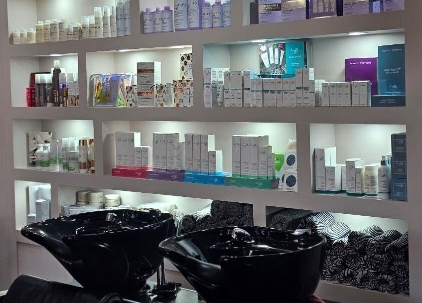 Erika’s Beauty salon wash area with premium products on display shelves in Derby, England, GB.
