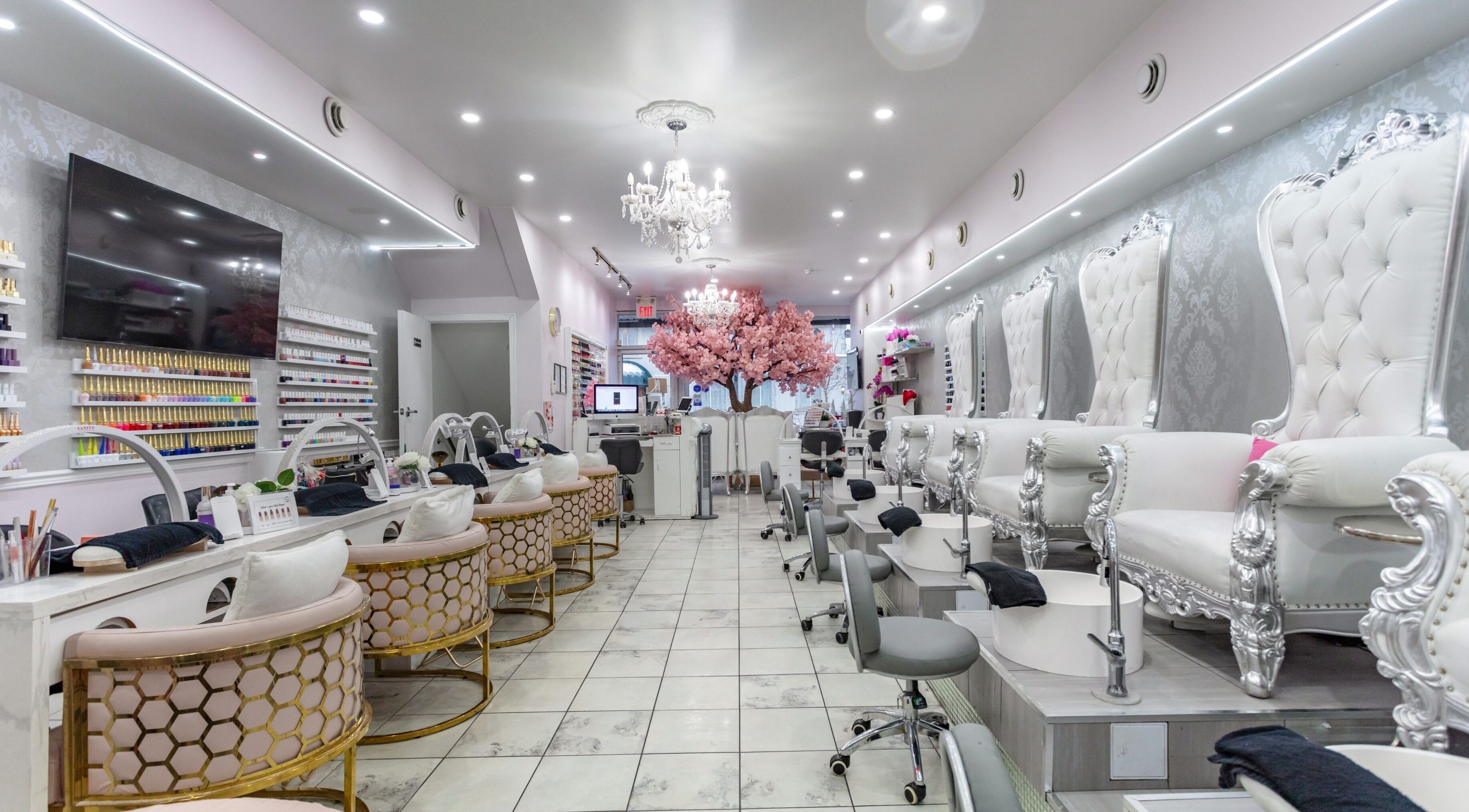 Chic interior of Vanity Nail & Beauty Bar in Toronto, Ontario, CA, featuring plush seating and a cherry blossom tree.