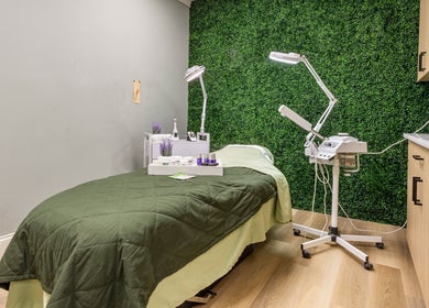 Relaxation room at Beautyology in Ooltewah, Tennessee, US with lush greenery, treatment bed, and spa equipment.