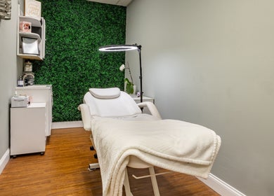 Relaxing treatment room at Beautyology, Ooltewah, Tennessee, US, featuring a plush spa bed and green decor.
