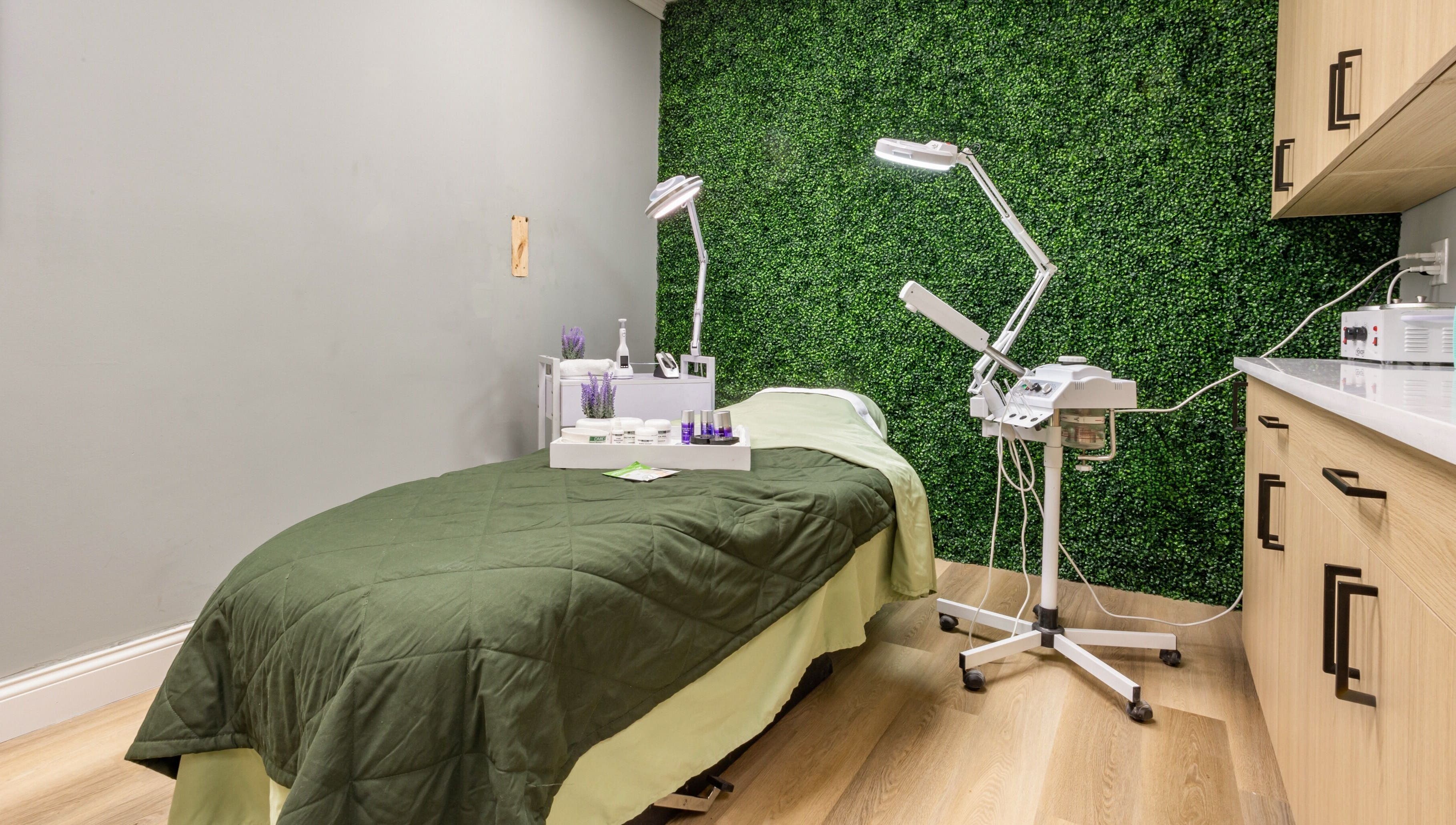 Relaxing treatment room at BEAUTYOLOGY, Ooltewah, Tennessee, US, featuring a green wall and spa essentials.