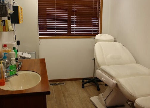 Relaxing treatment room at Skin Passion in Red Beach, Auckland, NZ, featuring a plush chair and essential supplies.