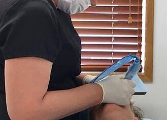 Therapist performing facial treatment at Skin Passion in Red Beach, Auckland, NZ, enhancing relaxation.