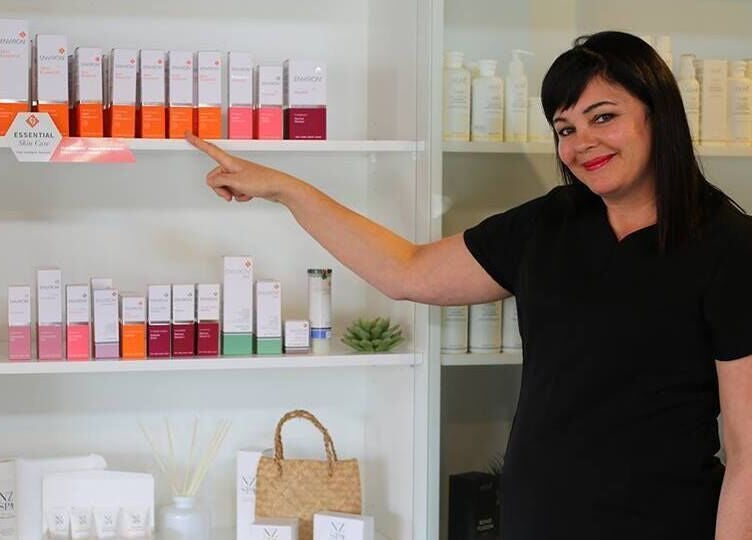 Staff member showcasing skincare products at Skin Passion, Red Beach, Auckland, NZ.