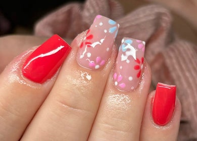 Vibrant red and floral nail art at Charlotte Amelia Beauty, Penryn, England, GB showcasing intricate designs.