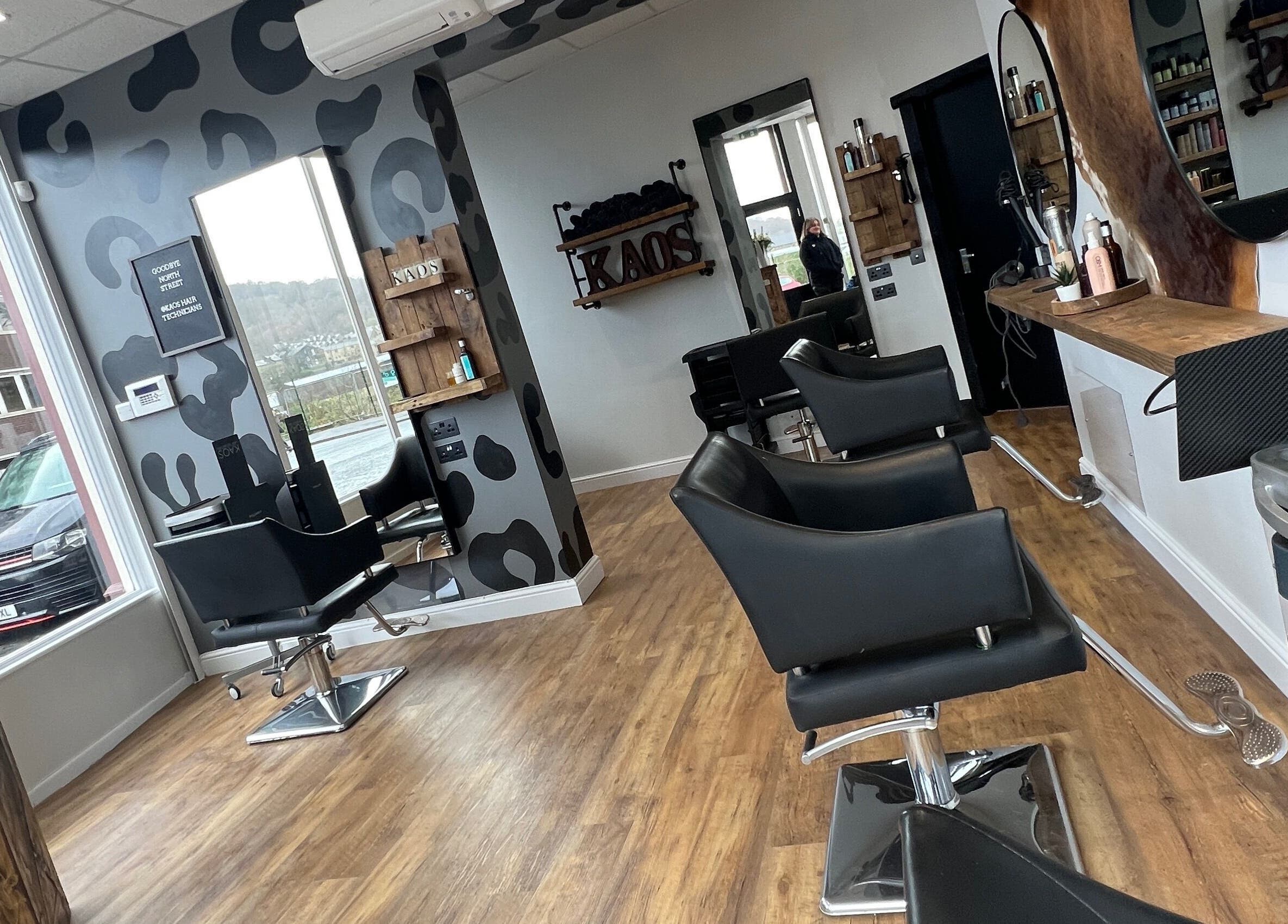 Modern interior of Kaos salon in Keighley, England, GB with stylish black chairs and wood accents.
