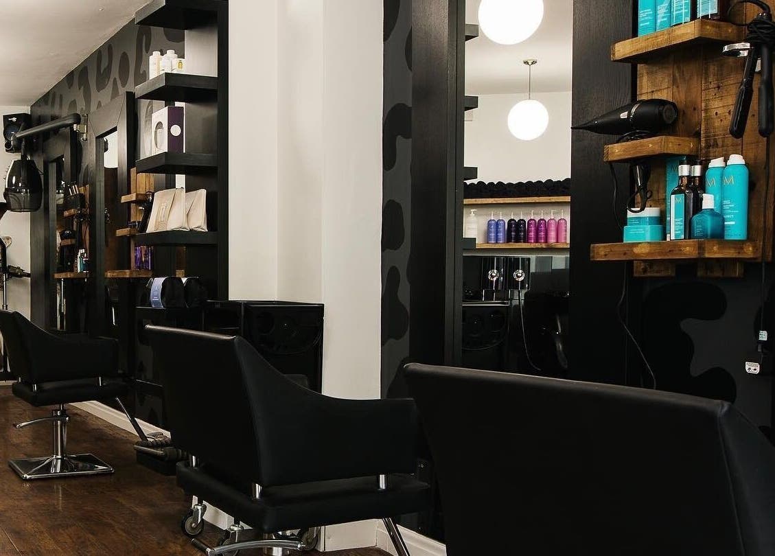 Modern salon interior at Kaos, Keighley, England, GB with sleek chairs and stylish product display.