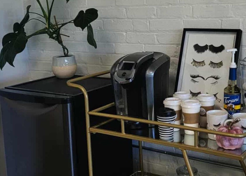 Cozy coffee station at The Lash Co., Windsor, Ontario, CA with coffee maker, cups, syrups, and eyelash art.