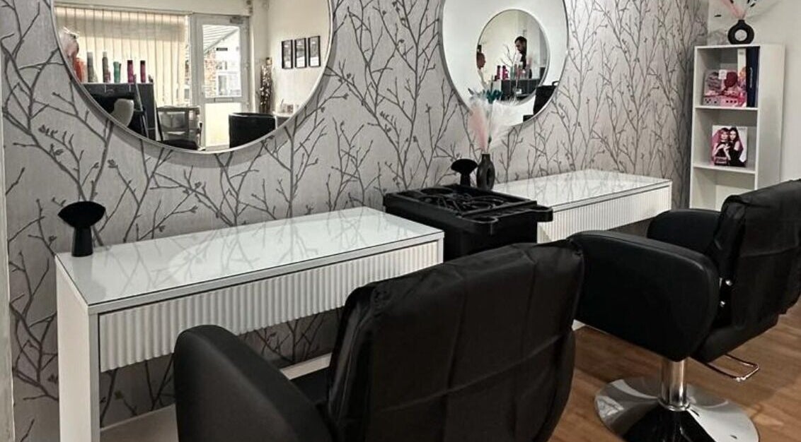 Elegant salon interior at Frampton’s Hair & Beauty, Bristol, GB featuring modern styling chairs and mirrors.