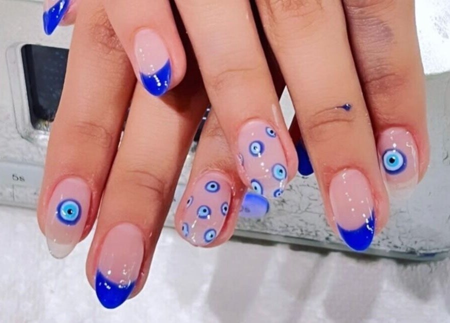 Stylish blue and nude nail art with evil eye design at NailBar Studio, Naperville, IL, US.