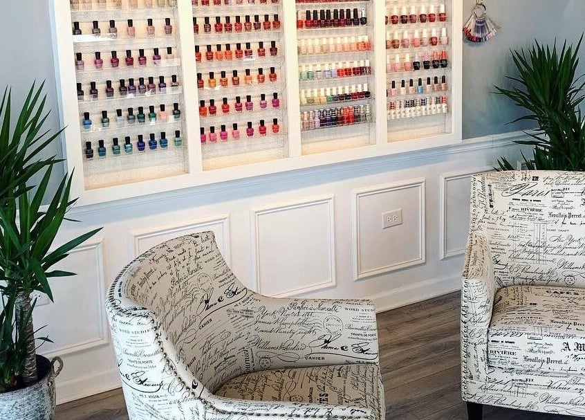 Nail polish display with elegant seating at NailBar Studio, Naperville, IL, US. Chic and inviting atmosphere.