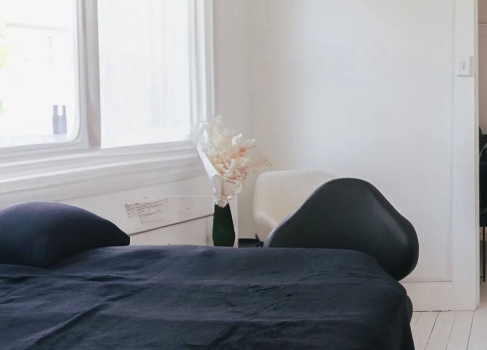 Cozy treatment room at Sheina Mill Studio, Bondi Beach, New South Wales, AU with black bed and modern decor.