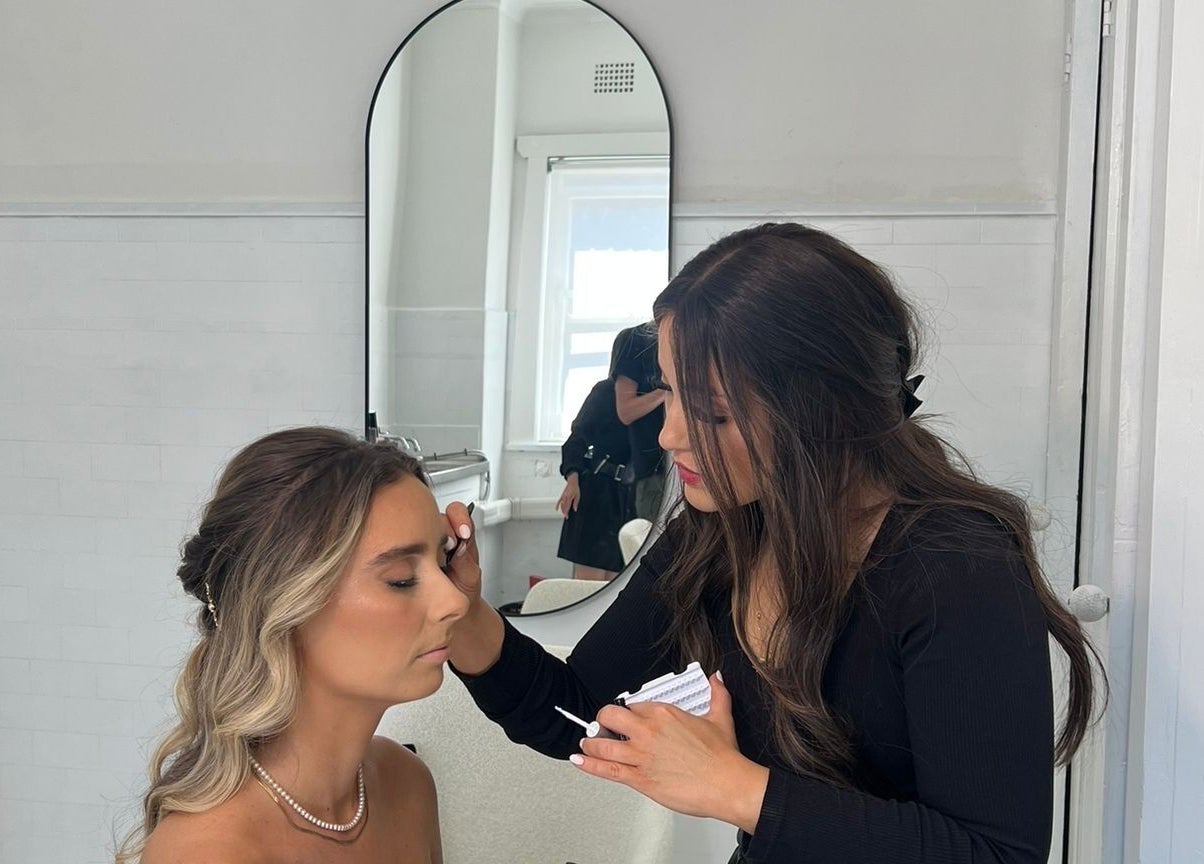 Makeup artist at Sheina Mill Studio in Bondi Beach, New South Wales, AU, gracefully applying eyeshadow.