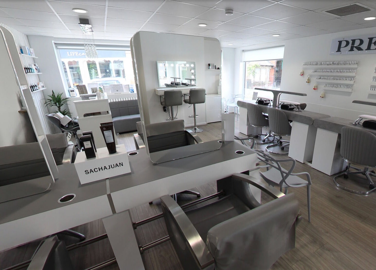 Modern beauty salon interior at Prept Romiley, Romiley, England, GB featuring stylish nail stations and mirrors.