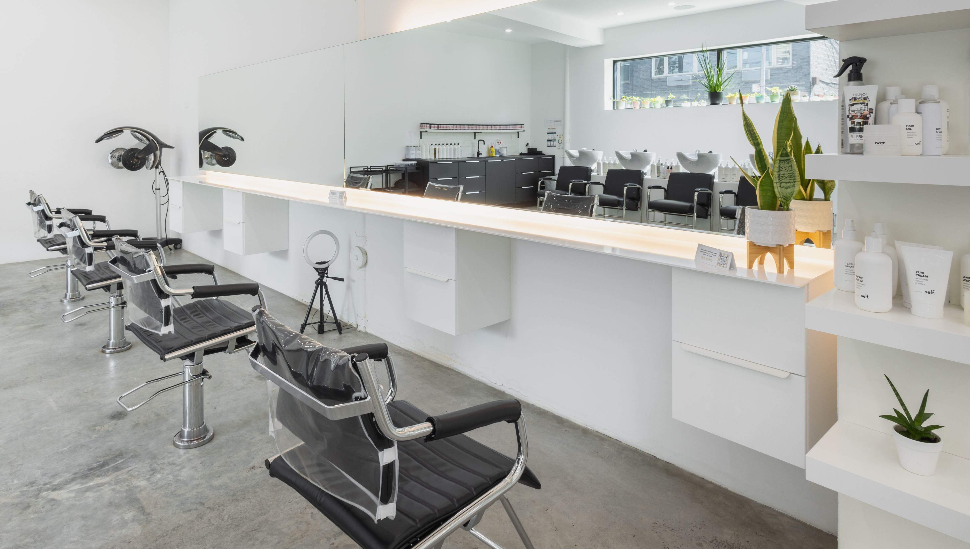 Modern salon interior at Self Bushwick, New York, New York, US with sleek chairs and mirrors.