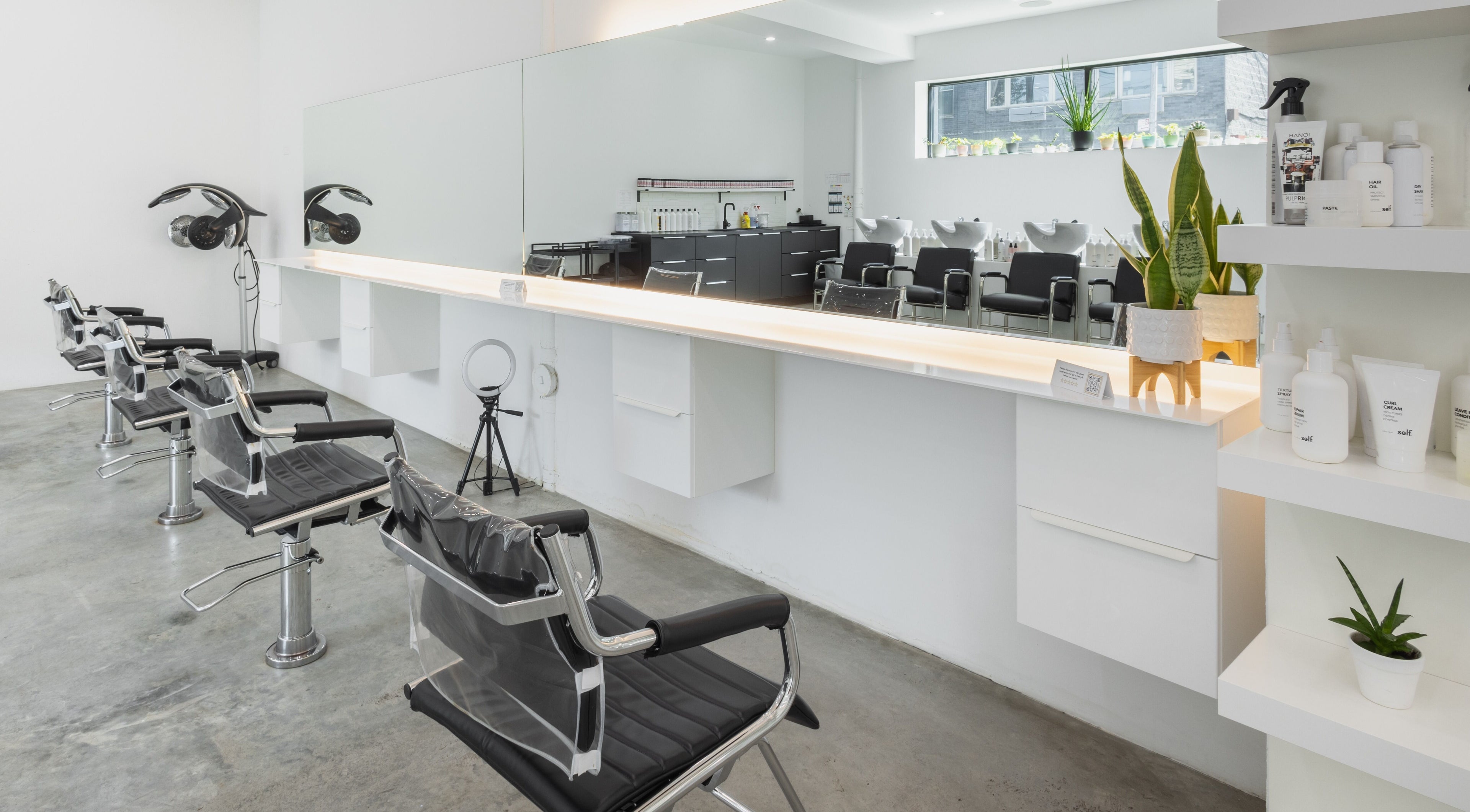 Modern salon interior at Self Bushwick, New York, New York, US with sleek chairs and mirrors.