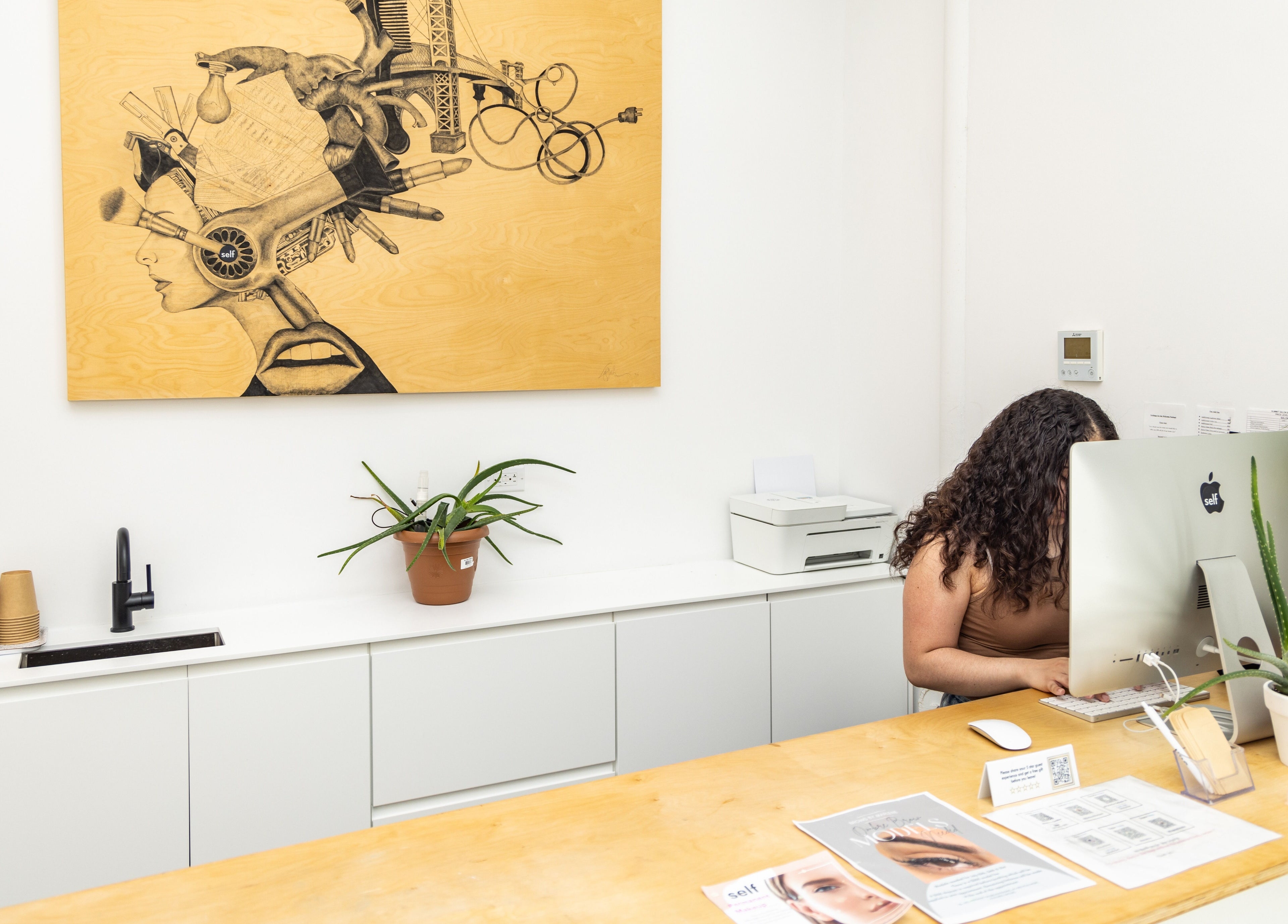 Reception area at Self Bushwick, New York, adorned with artwork and plants, creating a calming ambiance.