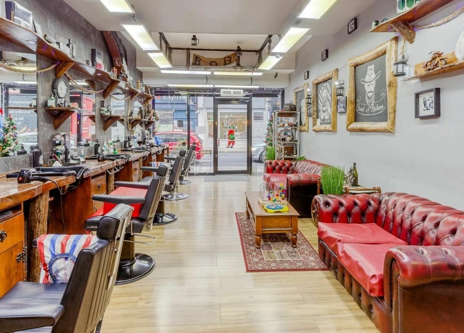 Interior of Band of Barbers VIP Fulham, London, England, GB with vintage decor and leather chairs.