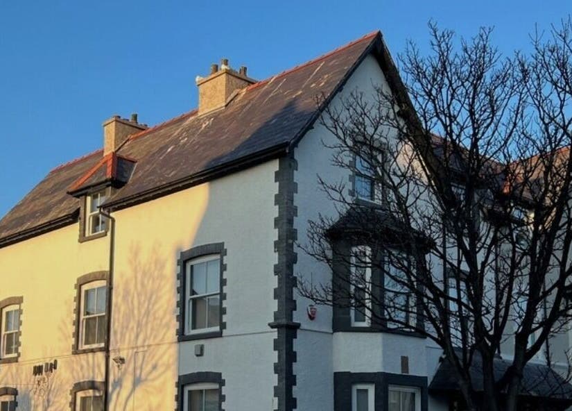 Charming exterior of Heal and Restore by Mia in Llandudno, Wales, GB with sunlit facade and tree.