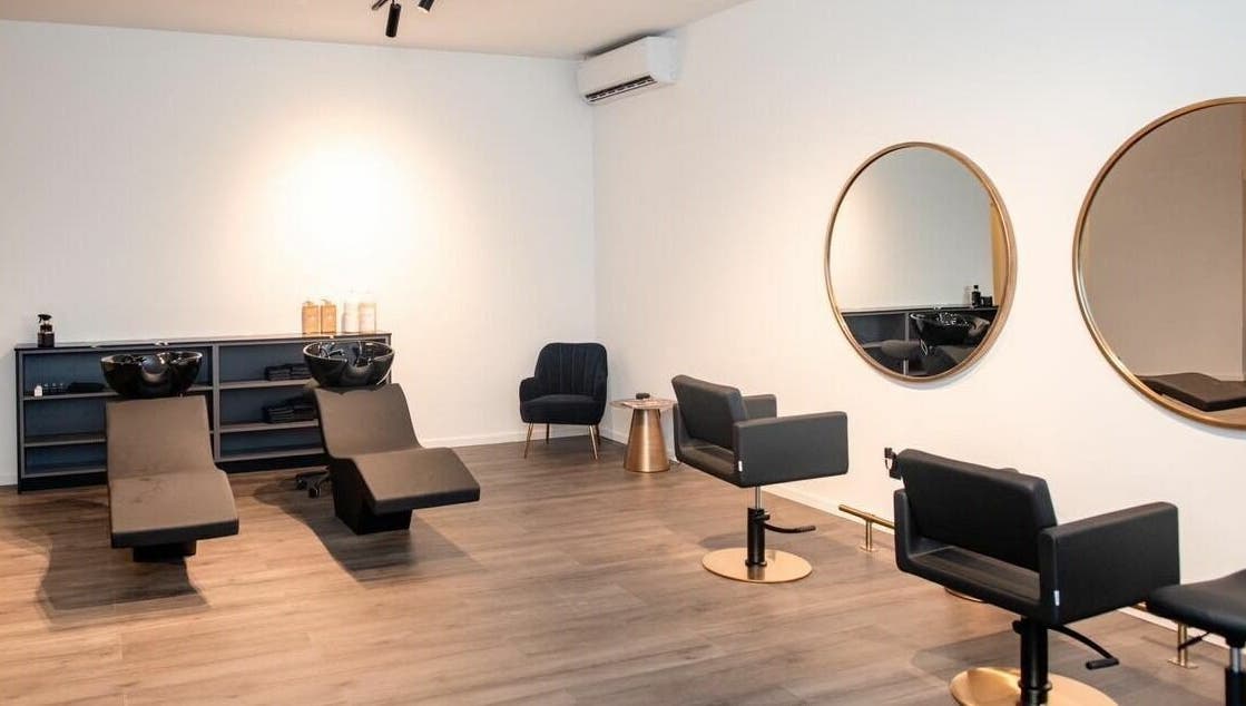 Stijlvolle salonruimte bij Delete Beauty Lounge in Paramaribo, Paramaribo, SR met moderne stoelen en spiegels.