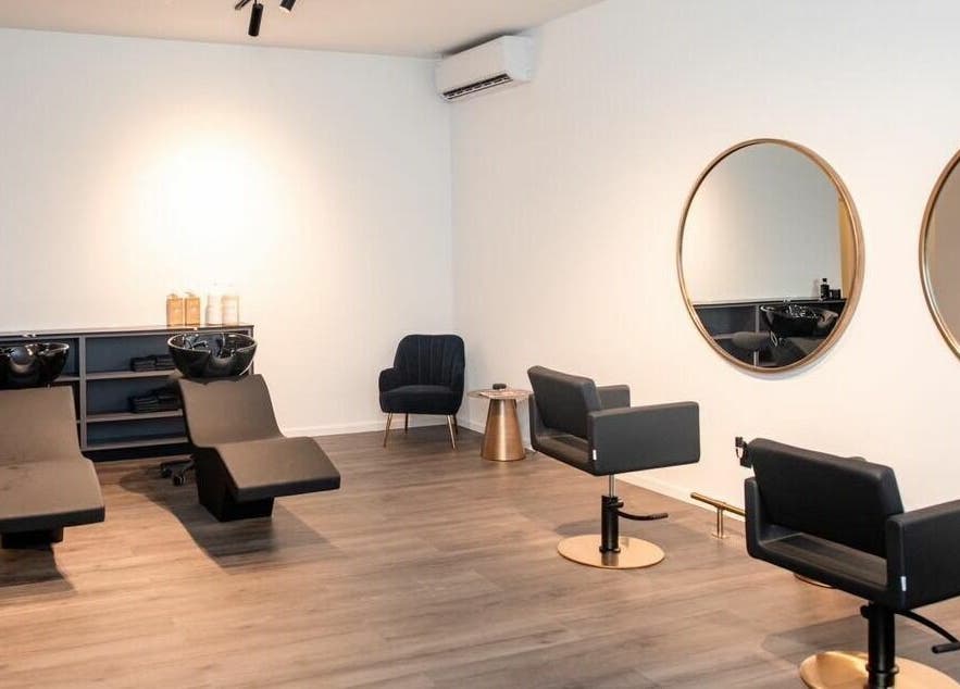 Stijlvolle salonruimte bij Delete Beauty Lounge in Paramaribo, Paramaribo, SR met moderne stoelen en spiegels.