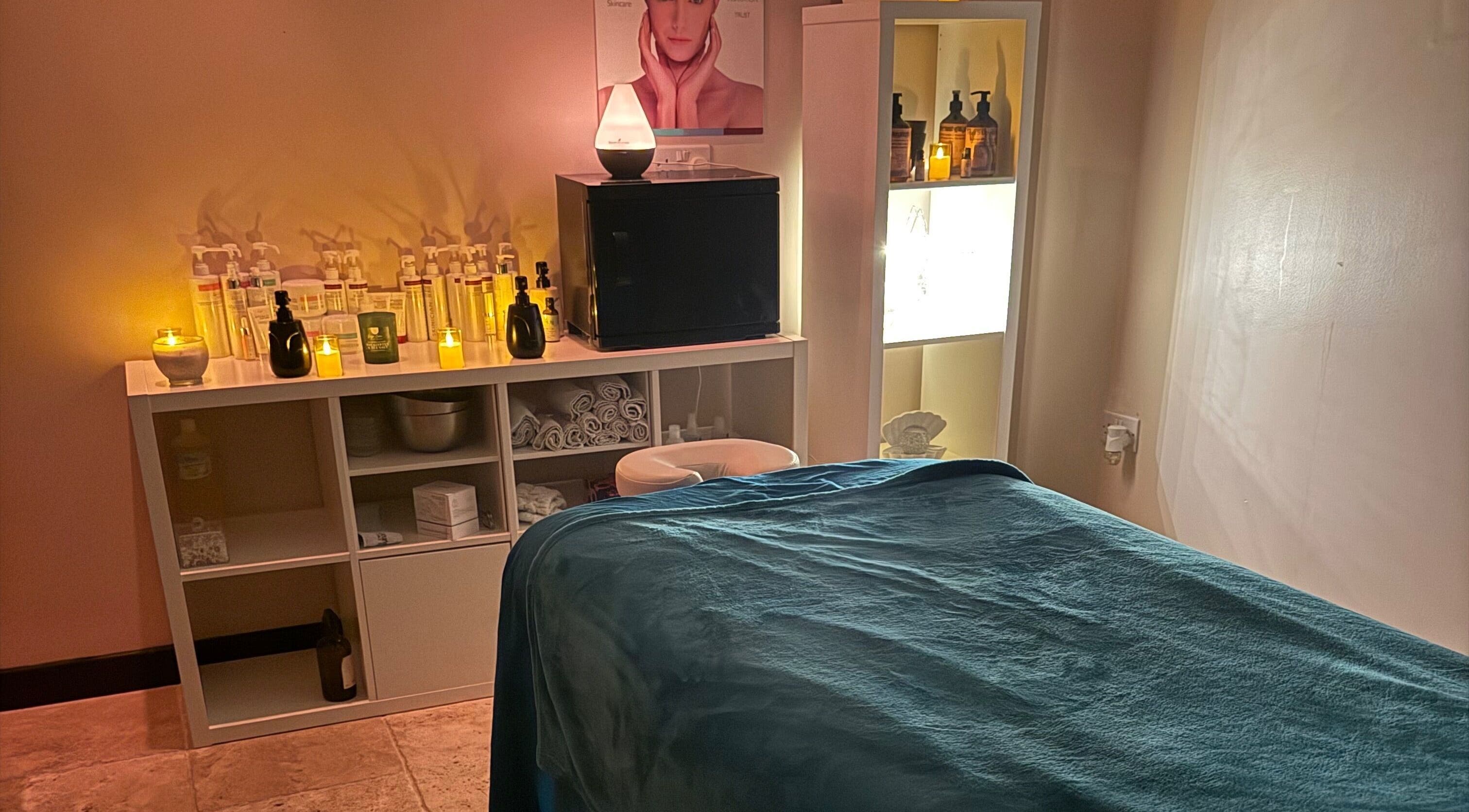 Cozy spa room at Lushious Luxuries, Belfast, Northern Ireland, GB, with calming candles and treatment bed.