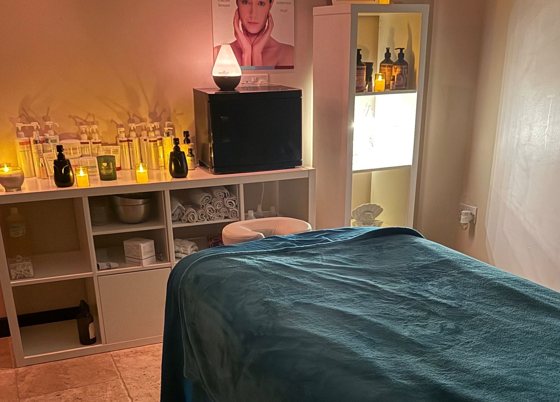 Tranquil spa room at Lushious Luxuries Day Spa, Belfast, Northern Ireland, GB with massage table and candles.