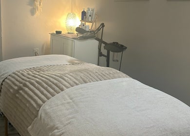 Relaxing treatment room at Elisha Marie Skin & Body, Palo Alto, California, US with a cozy massage table.